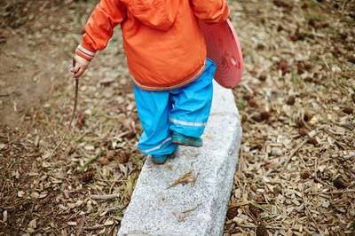 Kind balanciert auf Baumstamm